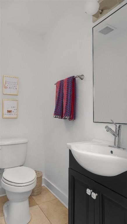 bathroom featuring vanity, visible vents, baseboards, tile patterned flooring, and toilet