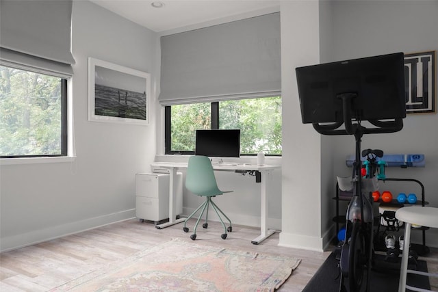 office area with light wood-style floors and baseboards