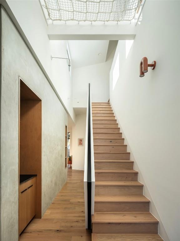 stairway featuring a high ceiling and hardwood / wood-style floors