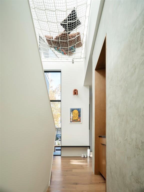 hallway with a high ceiling and light wood-type flooring