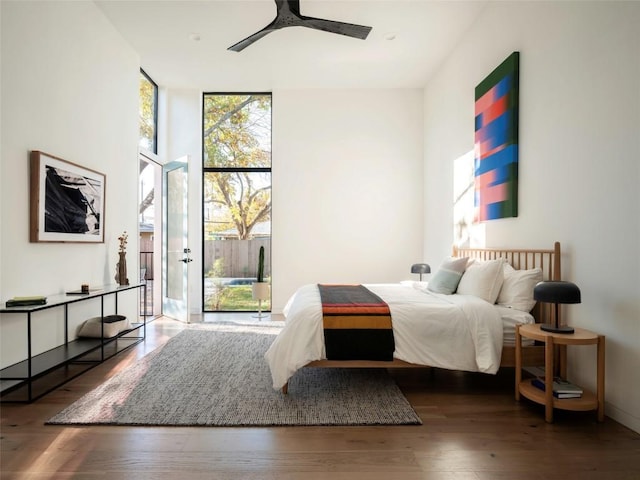 bedroom featuring floor to ceiling windows, ceiling fan, dark hardwood / wood-style flooring, and access to exterior