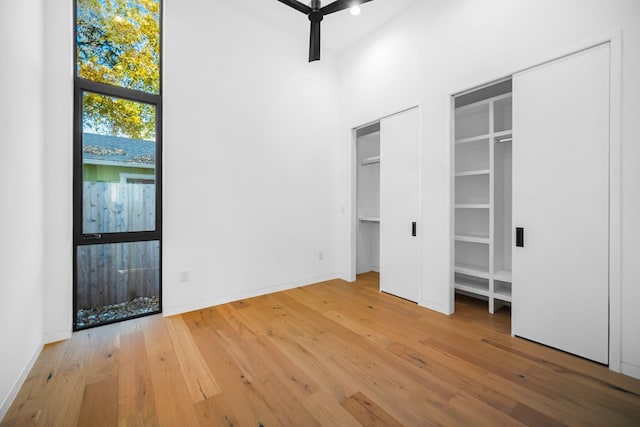 unfurnished bedroom featuring multiple closets and wood-type flooring