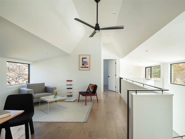 living room with light hardwood / wood-style floors, high vaulted ceiling, and ceiling fan