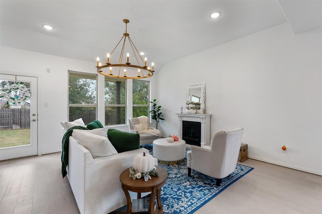 living room with light hardwood / wood-style floors and a notable chandelier