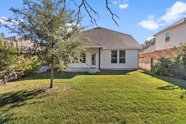 rear view of property featuring a yard