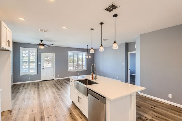 kitchen featuring sink, hanging light fixtures, stainless steel dishwasher, a kitchen island with sink, and white cabinets