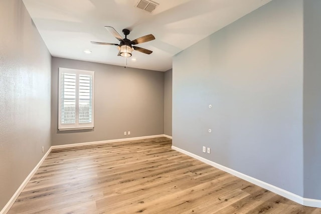 empty room with ceiling fan and light hardwood / wood-style floors