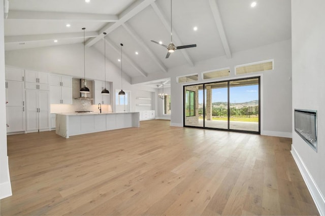 917 Bristol Creek Bnd, Lakeway, TX 78738 - unfurnished living room with high vaulted ceiling, a fireplace, light wood-type flooring, beamed ceiling, and a chandelier