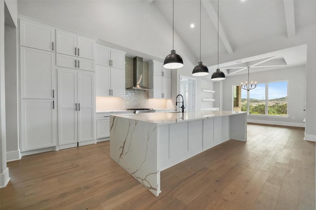 917 Bristol Creek Bnd, Lakeway, TX 78738 - kitchen with wall chimney exhaust hood, a chandelier, light wood-type flooring, a large island with sink, and recessed lighting