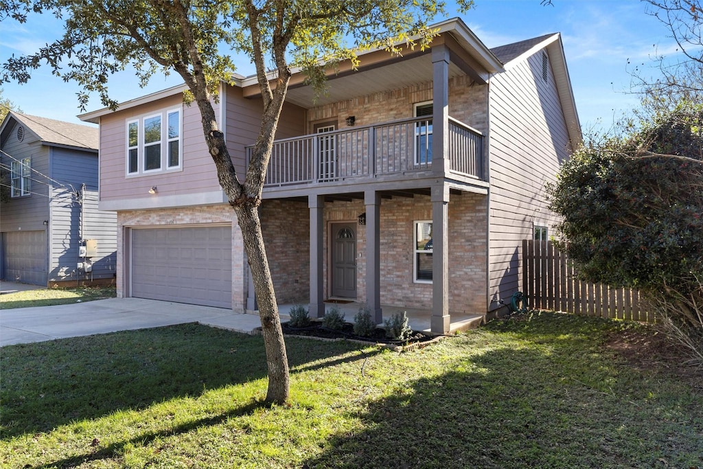 view of front of property featuring a balcony, a front yard, and a garage