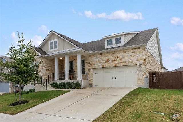 view of front of house featuring a front lawn, a porch, fence, board and batten siding, and concrete driveway