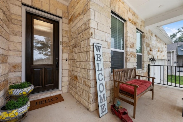 property entrance featuring stone siding and a porch
