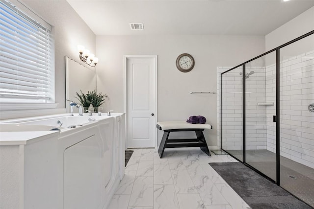 full bathroom featuring marble look tile flooring and a shower stall