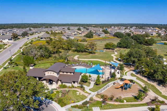 aerial view of property and surrounding area featuring a pool area and nearby suburban area