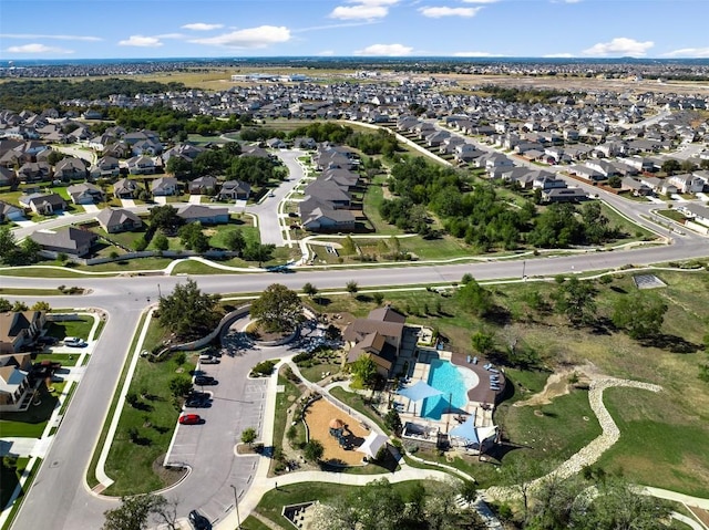 aerial view of property's location with a pool and nearby suburban area