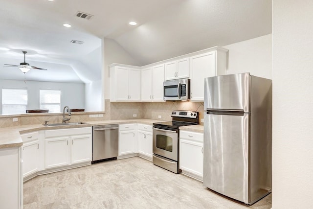 kitchen featuring white cabinetry, sink, ceiling fan, vaulted ceiling, and appliances with stainless steel finishes