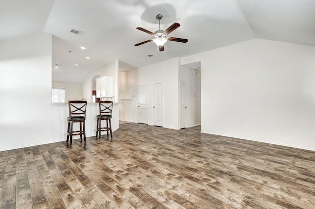 living room featuring ceiling fan, dark hardwood / wood-style flooring, and vaulted ceiling