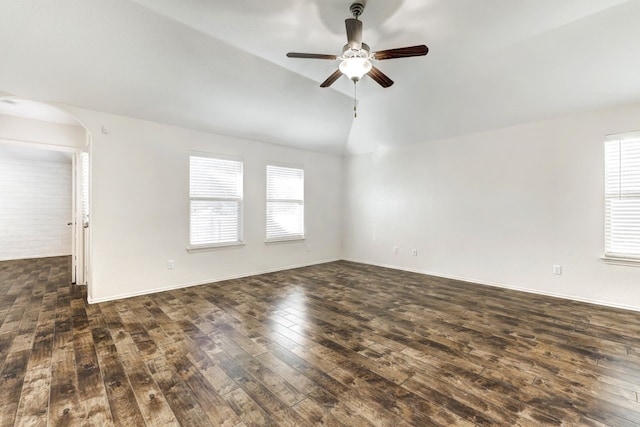 spare room with ceiling fan, dark wood-type flooring, and vaulted ceiling