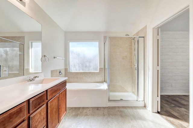 bathroom with independent shower and bath, vanity, wood-type flooring, and vaulted ceiling