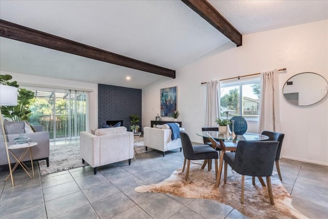 dining room featuring a textured ceiling, lofted ceiling with beams, and a fireplace