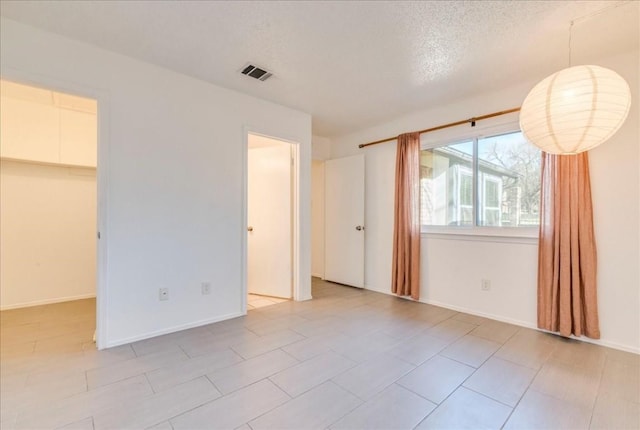 unfurnished room with a textured ceiling