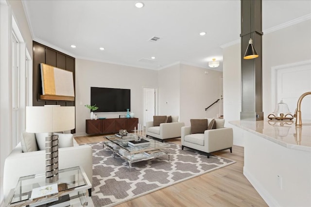 living room with light hardwood / wood-style floors and ornamental molding