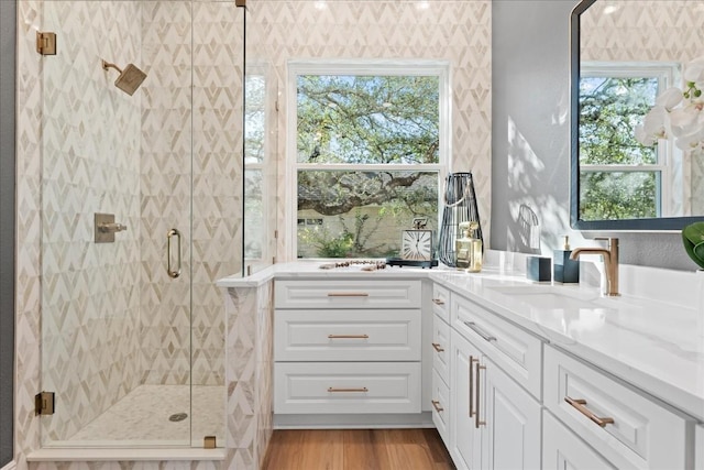 bathroom featuring a stall shower, wood finished floors, and vanity