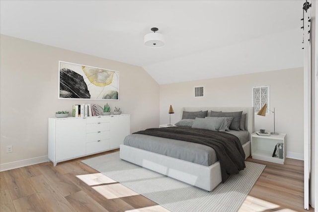 bedroom featuring vaulted ceiling and hardwood / wood-style floors