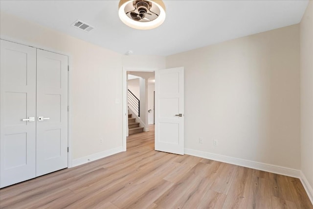 unfurnished bedroom featuring light hardwood / wood-style floors and a closet