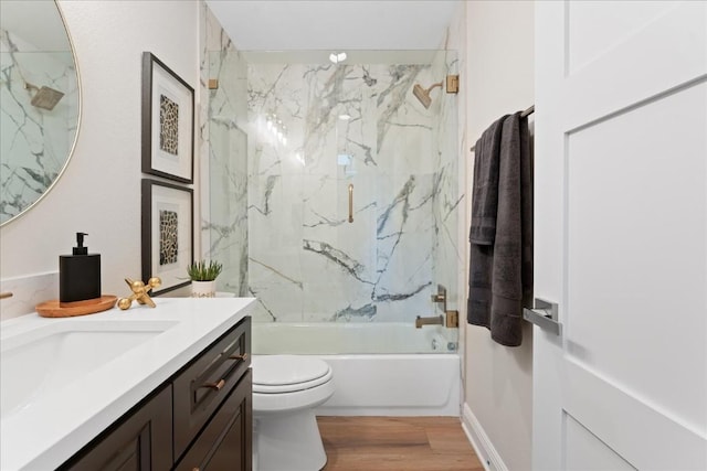 bathroom with toilet, shower / bathtub combination, wood finished floors, and vanity