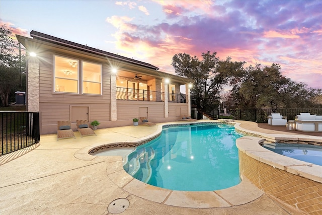 pool at dusk featuring a patio area, an in ground hot tub, and ceiling fan