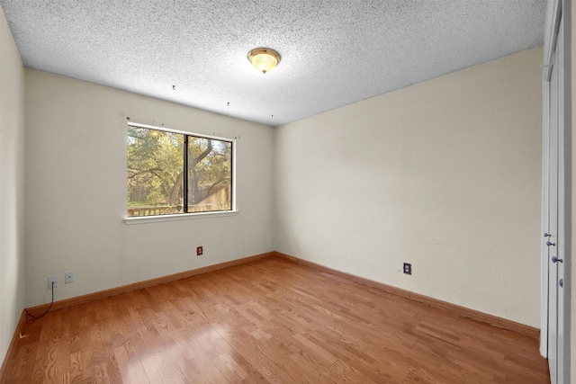 empty room featuring a textured ceiling and light wood-type flooring