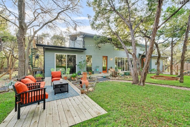 rear view of property featuring an outdoor hangout area, a balcony, and a lawn