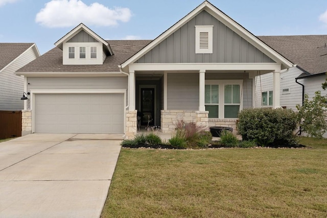 view of front of house with a front lawn, a porch, and a garage