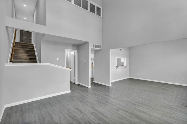 unfurnished living room featuring dark hardwood / wood-style floors and a high ceiling