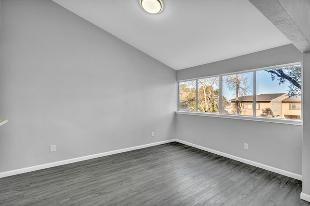 unfurnished room with dark wood-type flooring and vaulted ceiling