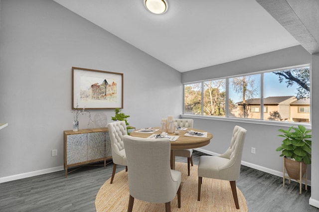 dining area featuring dark wood-type flooring and vaulted ceiling