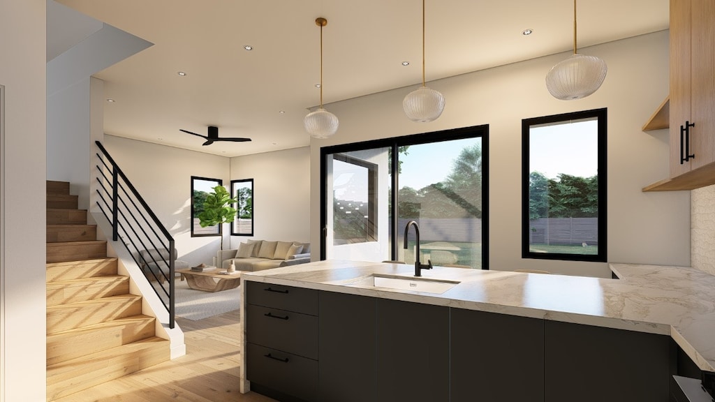 kitchen with pendant lighting, ceiling fan, sink, and light hardwood / wood-style flooring