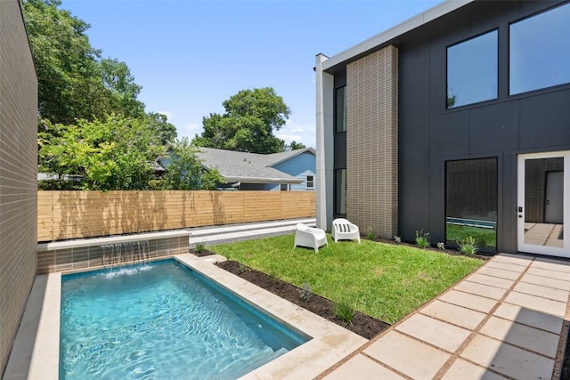 view of swimming pool with a yard and pool water feature