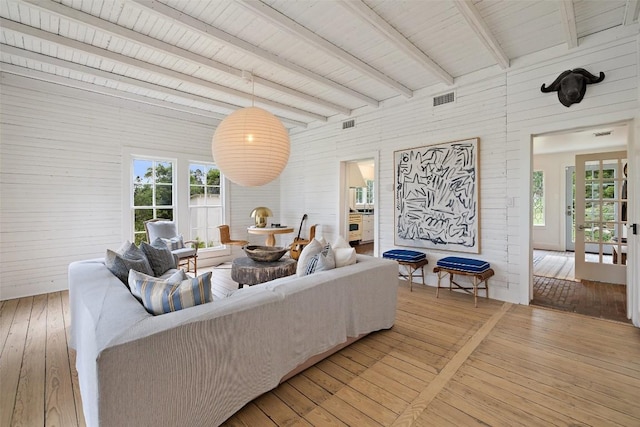 living room with hardwood / wood-style flooring, beamed ceiling, and a wealth of natural light