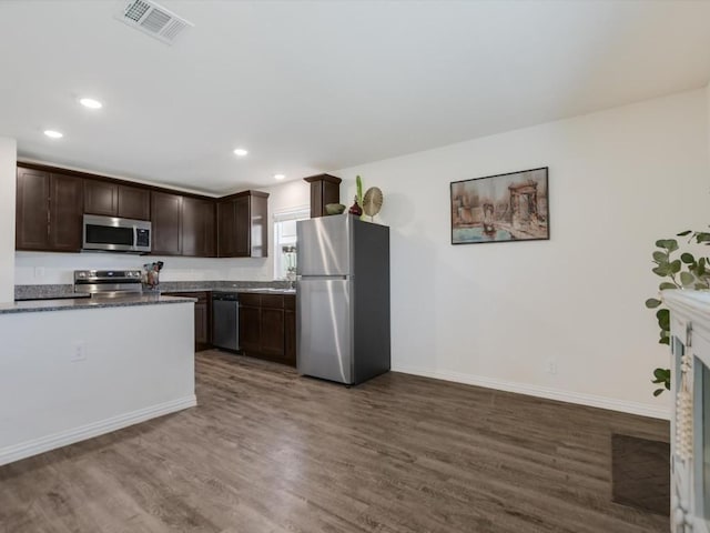 kitchen with dark hardwood / wood-style flooring, dark brown cabinets, and appliances with stainless steel finishes