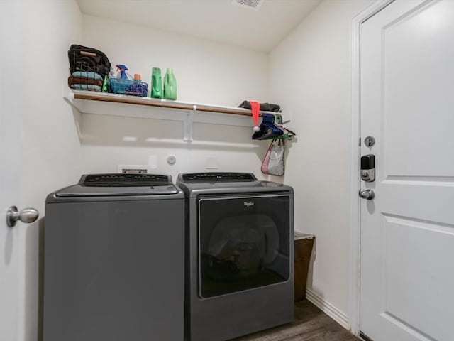 clothes washing area with dark hardwood / wood-style flooring and separate washer and dryer