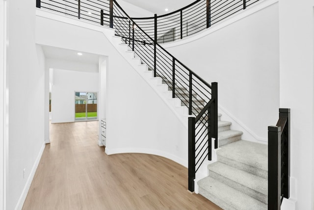 220 Reata Ridge Loop, Liberty Hill, TX 78642 - staircase with wood finished floors, a high ceiling, and baseboards