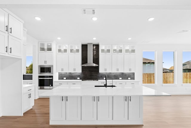 220 Reata Ridge Loop, Liberty Hill, TX 78642 - kitchen featuring stainless steel appliances, wall chimney range hood, a sink, plenty of natural light, and recessed lighting