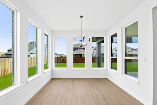 220 Reata Ridge Loop, Liberty Hill, TX 78642 - unfurnished sunroom with wood finished floors, a chandelier, plenty of natural light, and baseboards