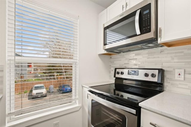 kitchen featuring backsplash, white cabinetry, and stainless steel appliances