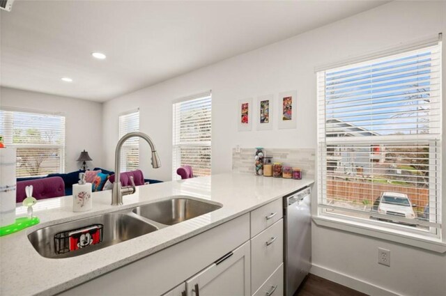 kitchen featuring kitchen peninsula, stainless steel dishwasher, a healthy amount of sunlight, and sink