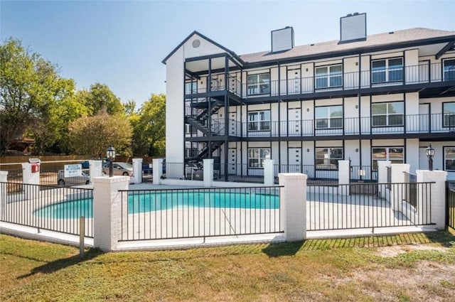 view of pool featuring a lawn and a patio