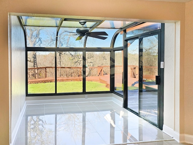 unfurnished sunroom with ceiling fan