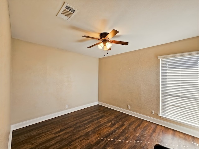 spare room with dark wood-type flooring and ceiling fan